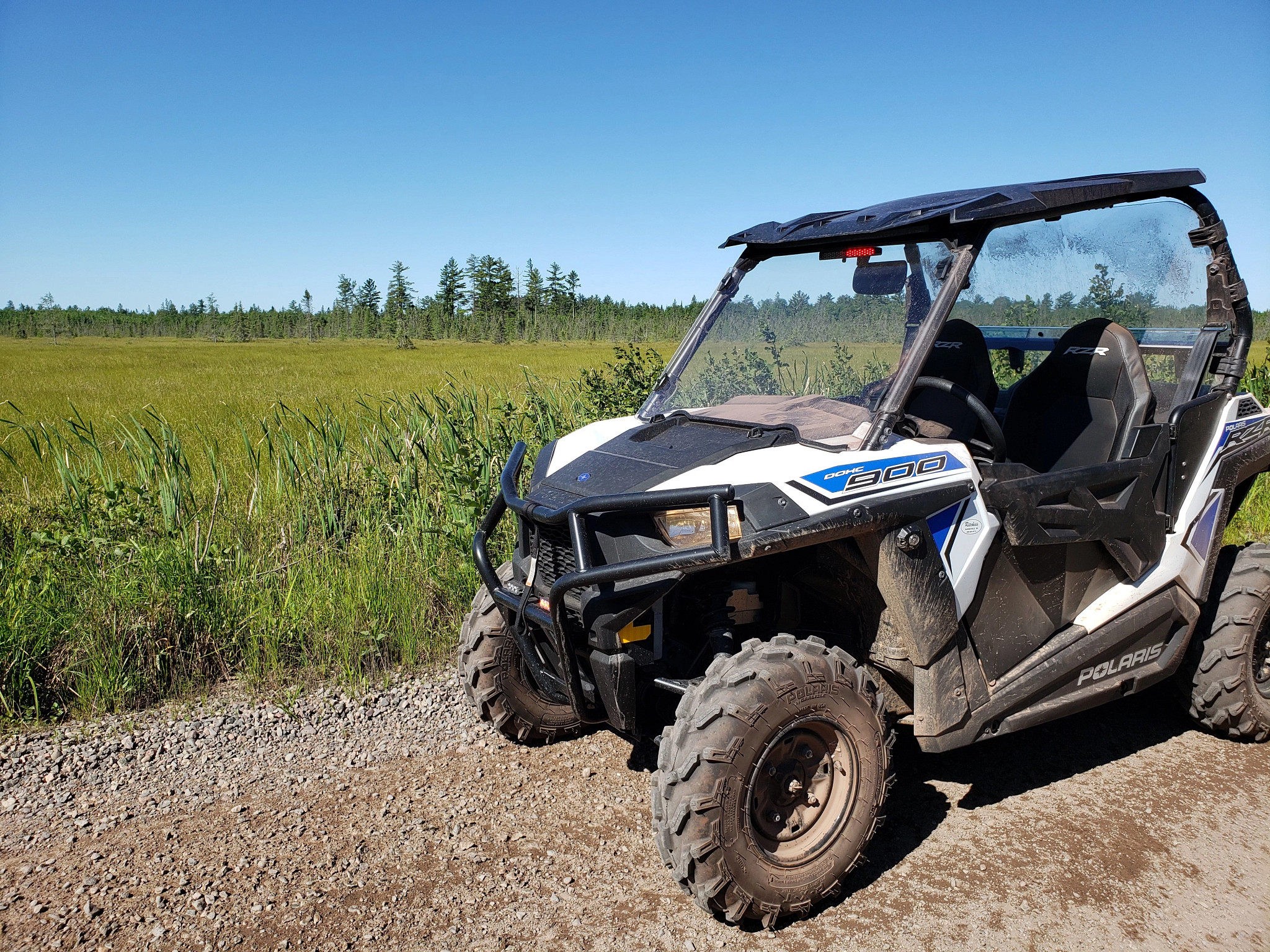 An ATV sits in front of a field. 