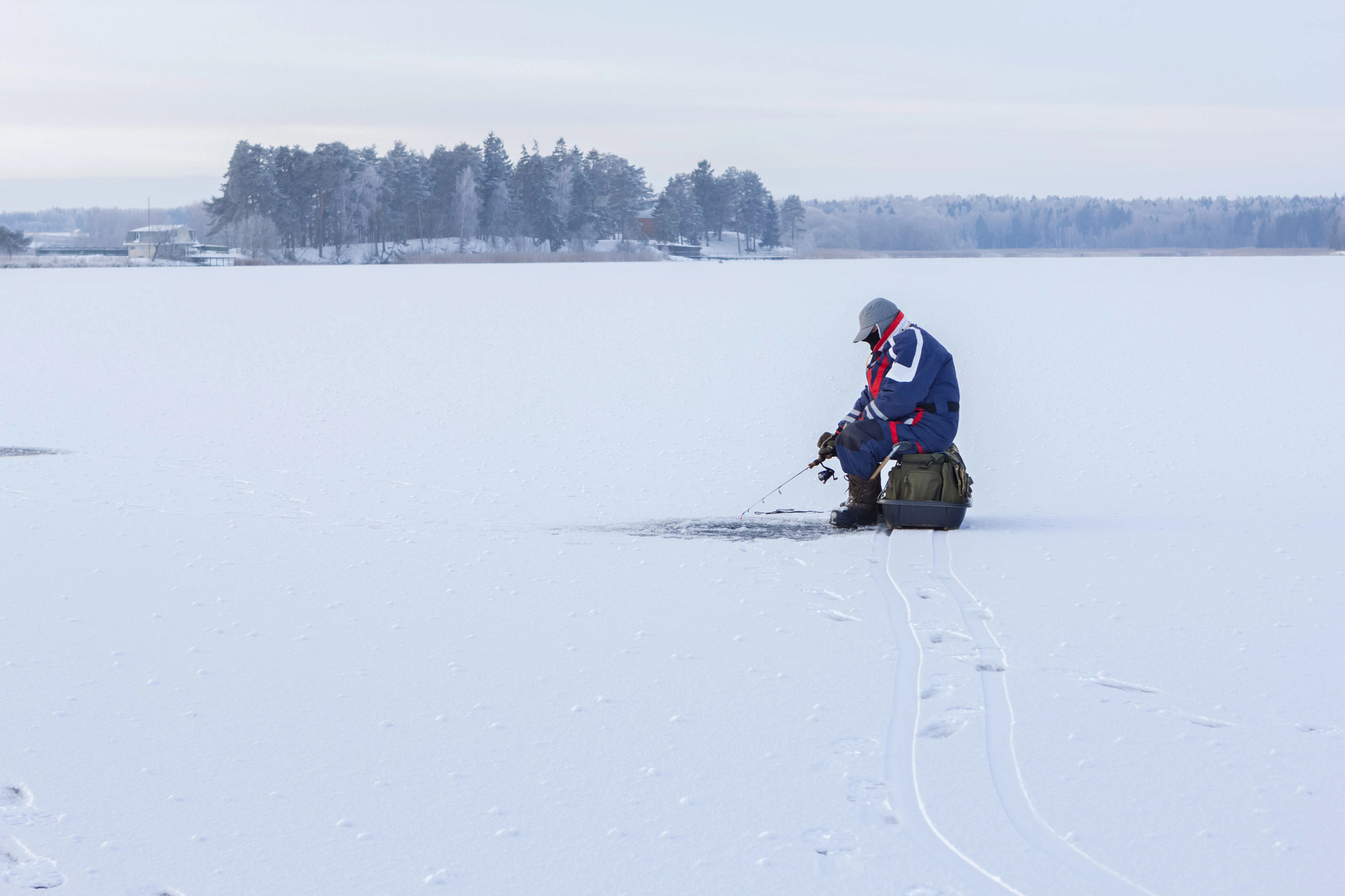 Ice fisherman on frozen lake