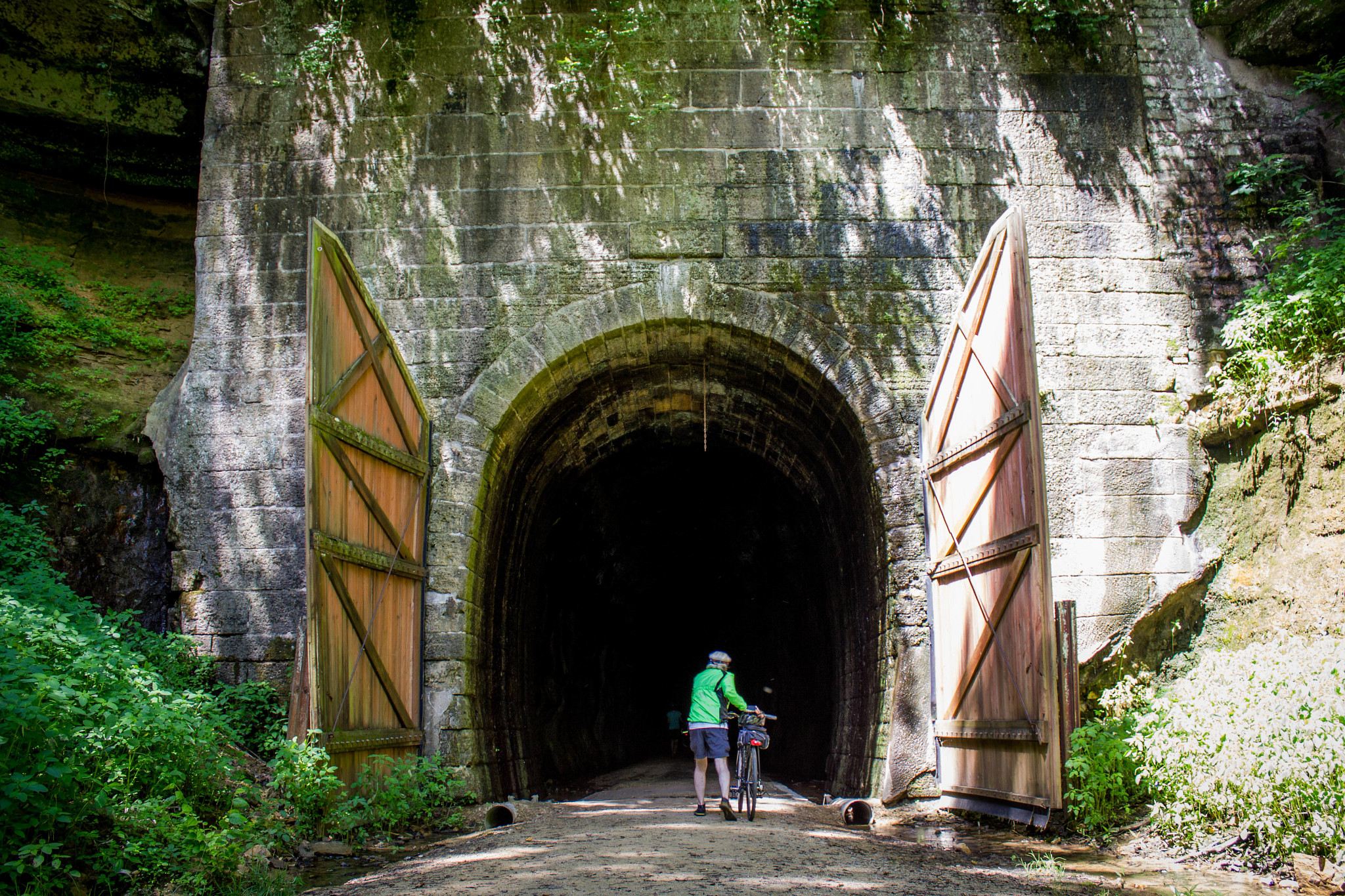 male biker stands in front of tunnel along elroy-sparta state trail