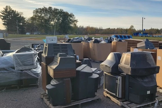 boxes of old electronics being recycled in a parking lot