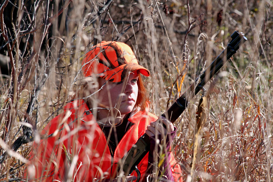 A woman hunting in a field.