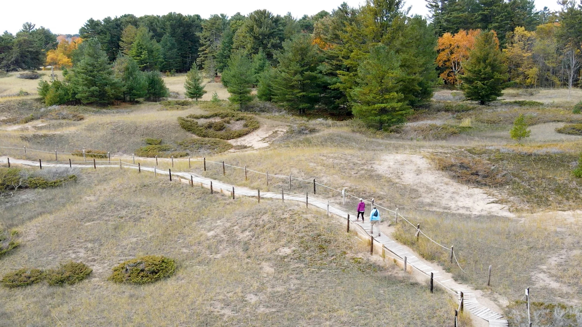 aerial image of two women walking along the boardwalk at kohler andrae state park