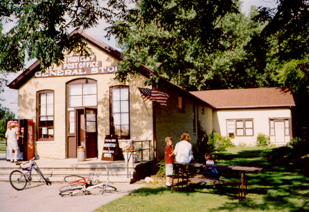 Image of the high cliff general store on a sunny day with bikes and a family outside.