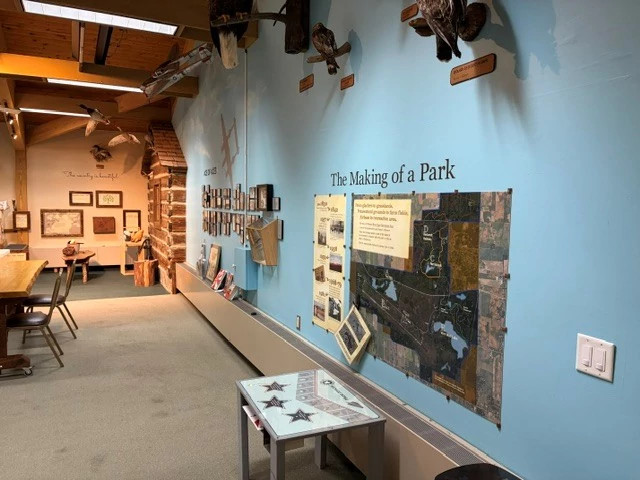 Visitor center wall with educational displays, one describing the history of the park.