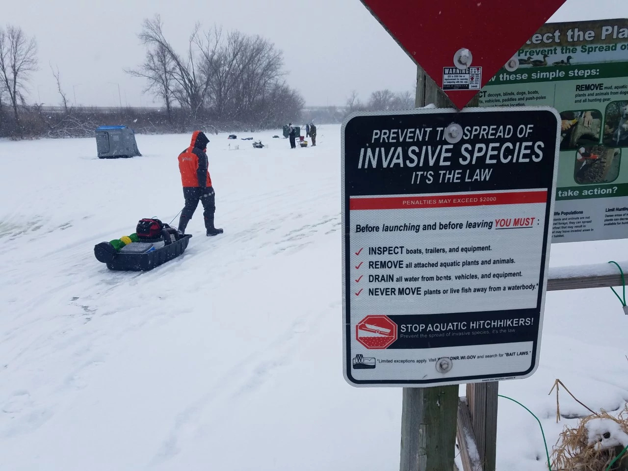 sign asking people to watch for invasive species at ice fishing location