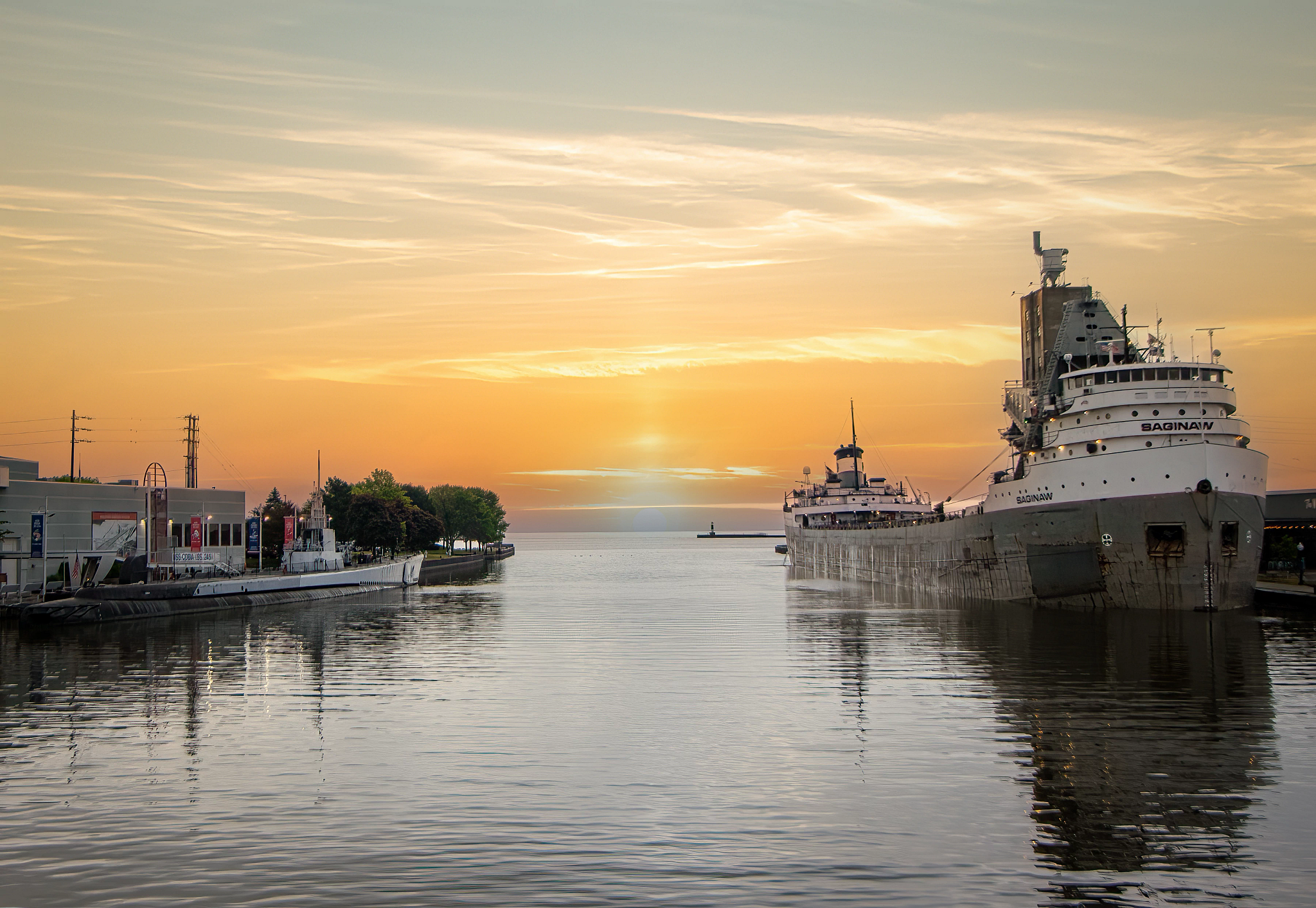 The Manitowoc River meets a golden sunrise as it flows into Lake Michigan. M/V Saginaw is docked at the port, across from the U.S.S. Cobia at the Manitowoc Maritime Museum.
