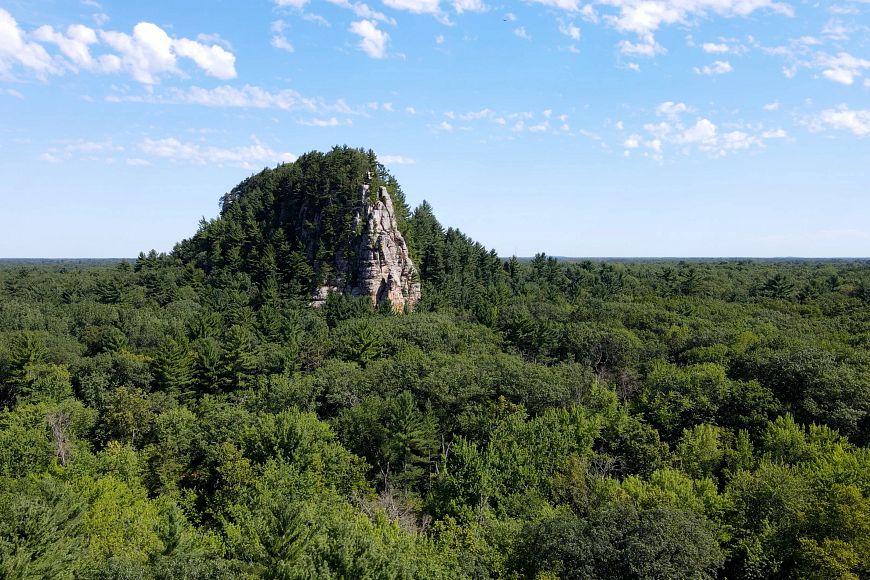 A sandstone rises above the surrounding trees.
