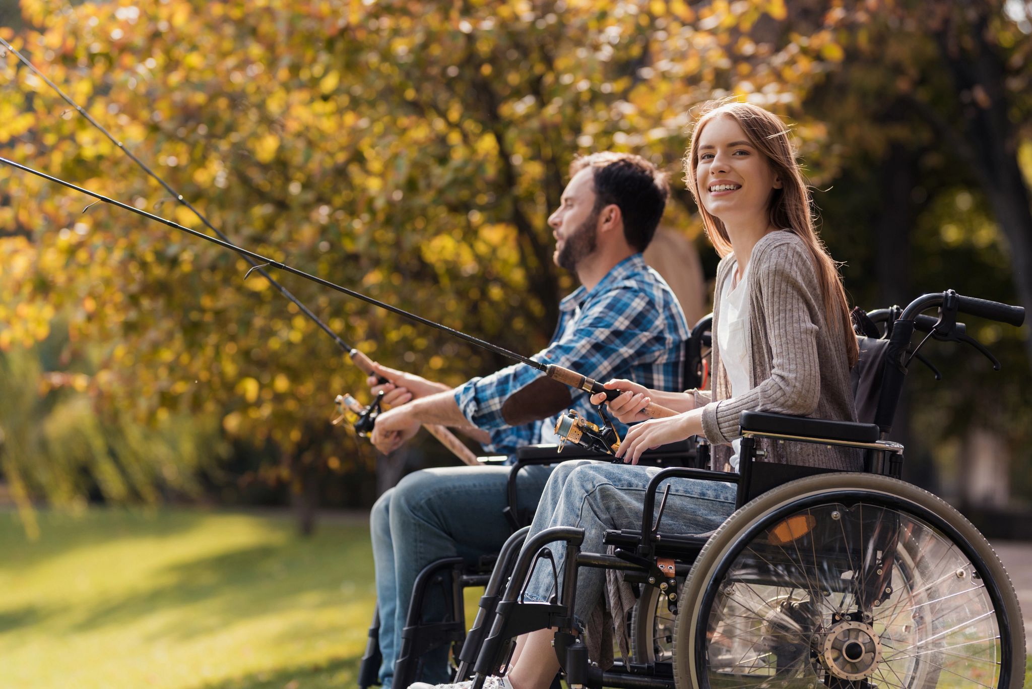 An image of two people in wheelchairs fishing.
