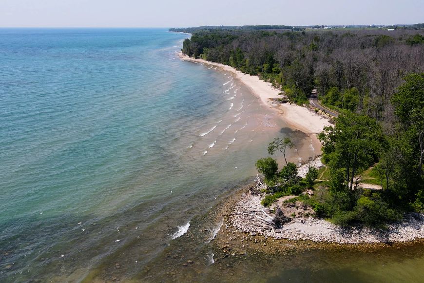 a drone photo of Harrington Beach State Park with forest and Lake Michigan