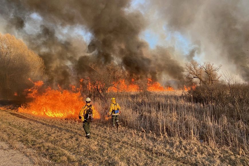 Two DNR firefighters patrolling a line of fire during a prescribed burn.