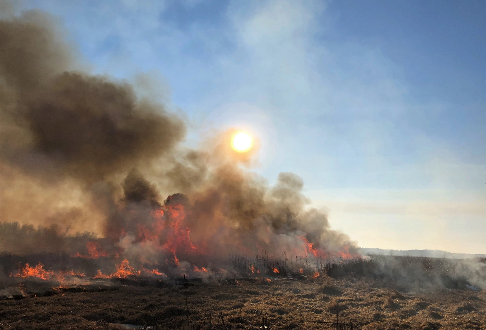 The sun sets behind smoke during a prescribed burn. 