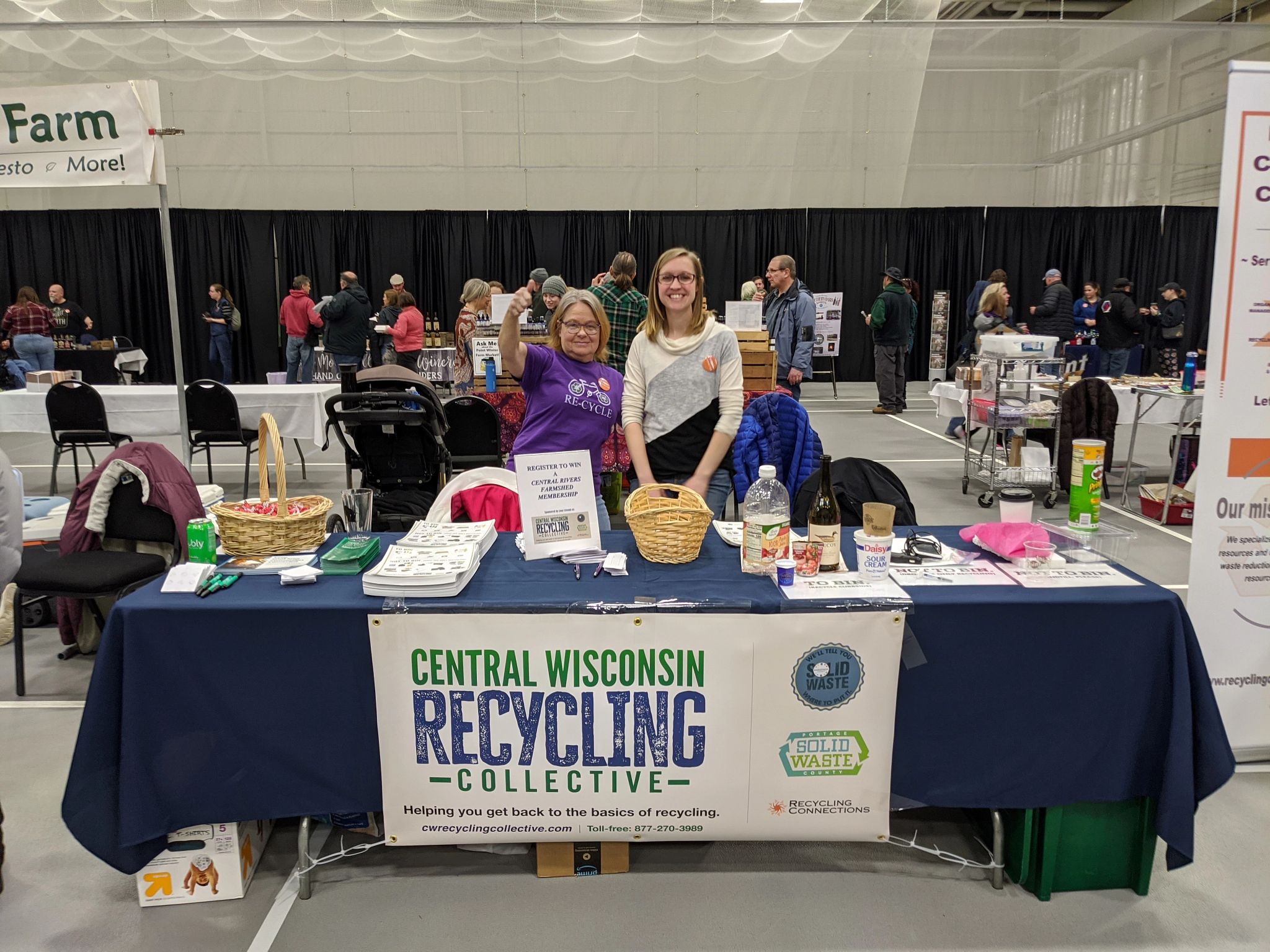 Representatives from the Central Wisconsin Recycling Collective (CWRC) stand in front of their booth. 