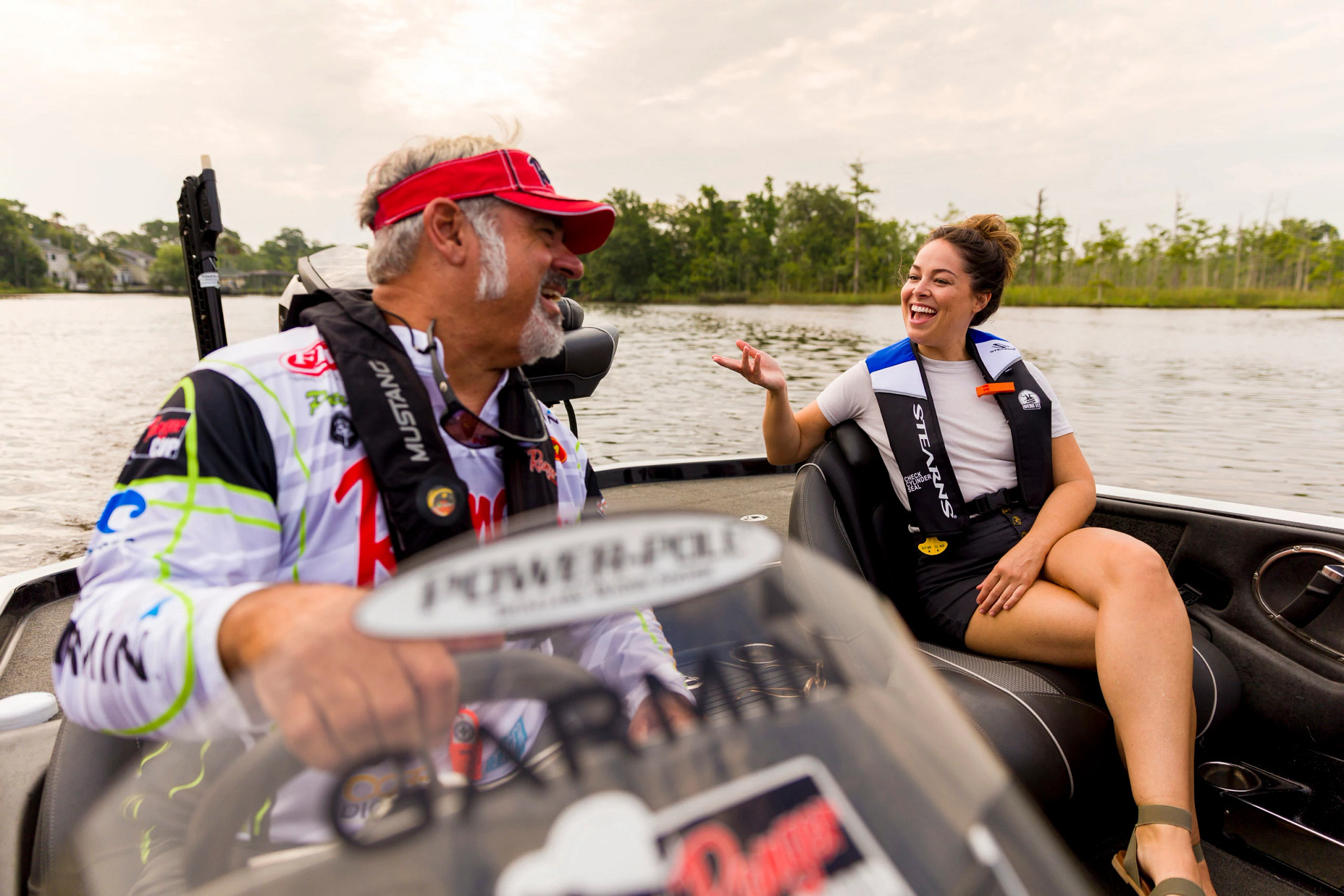 man and woman wearing life jackets on a powerboat