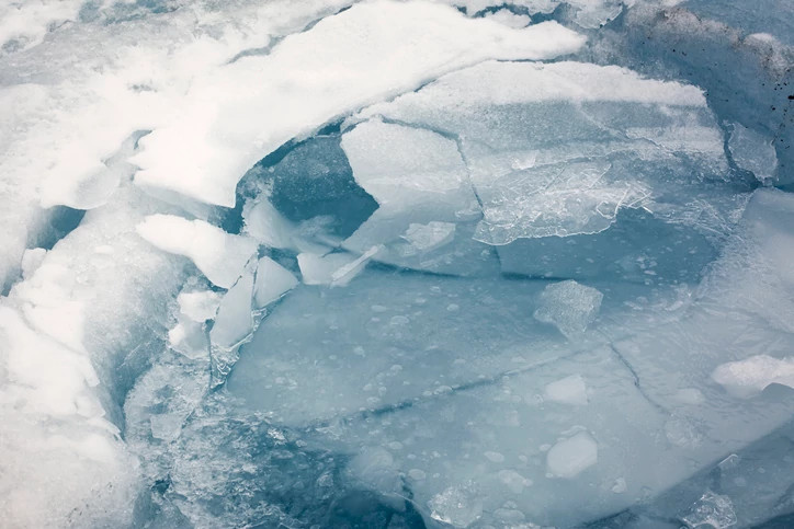 Horizontal close up view of a broken thin layer of ice