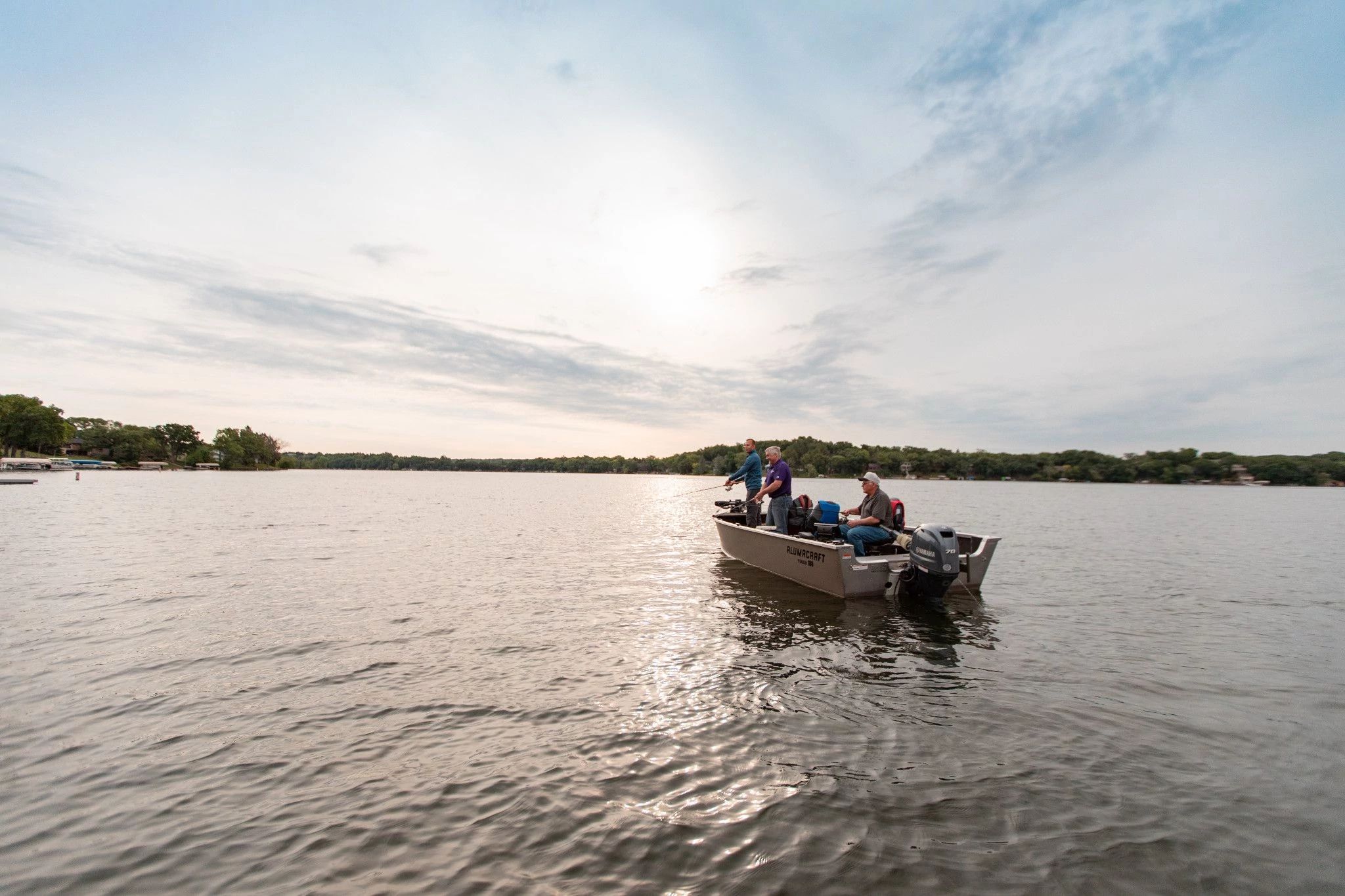 a small metal boat fishing in the middle of the lake