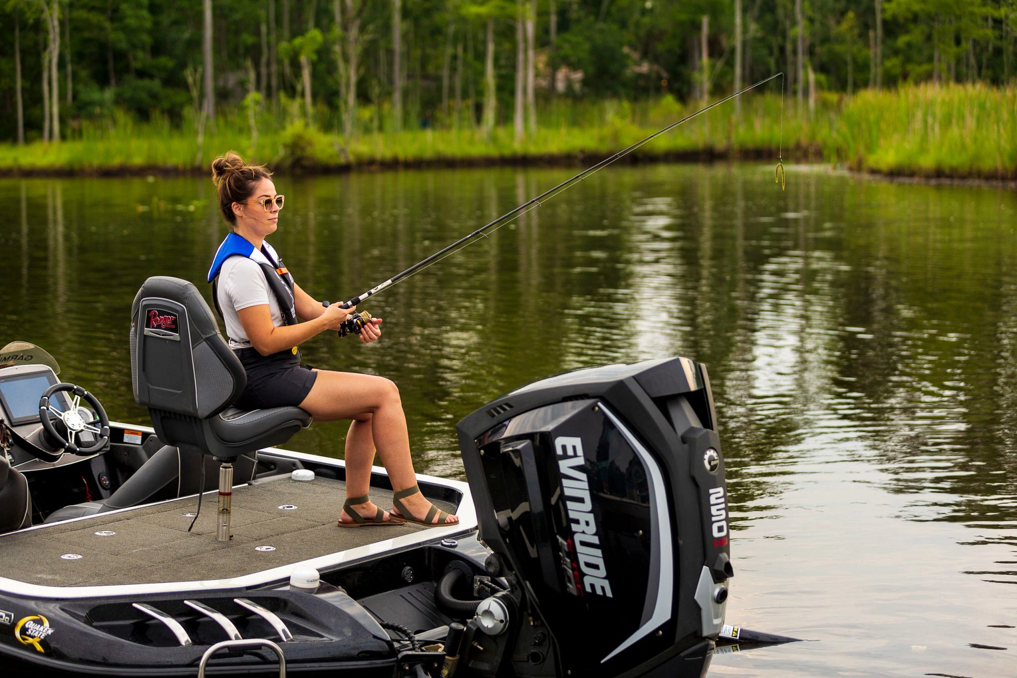An image of a female angler fishing on a boat. 