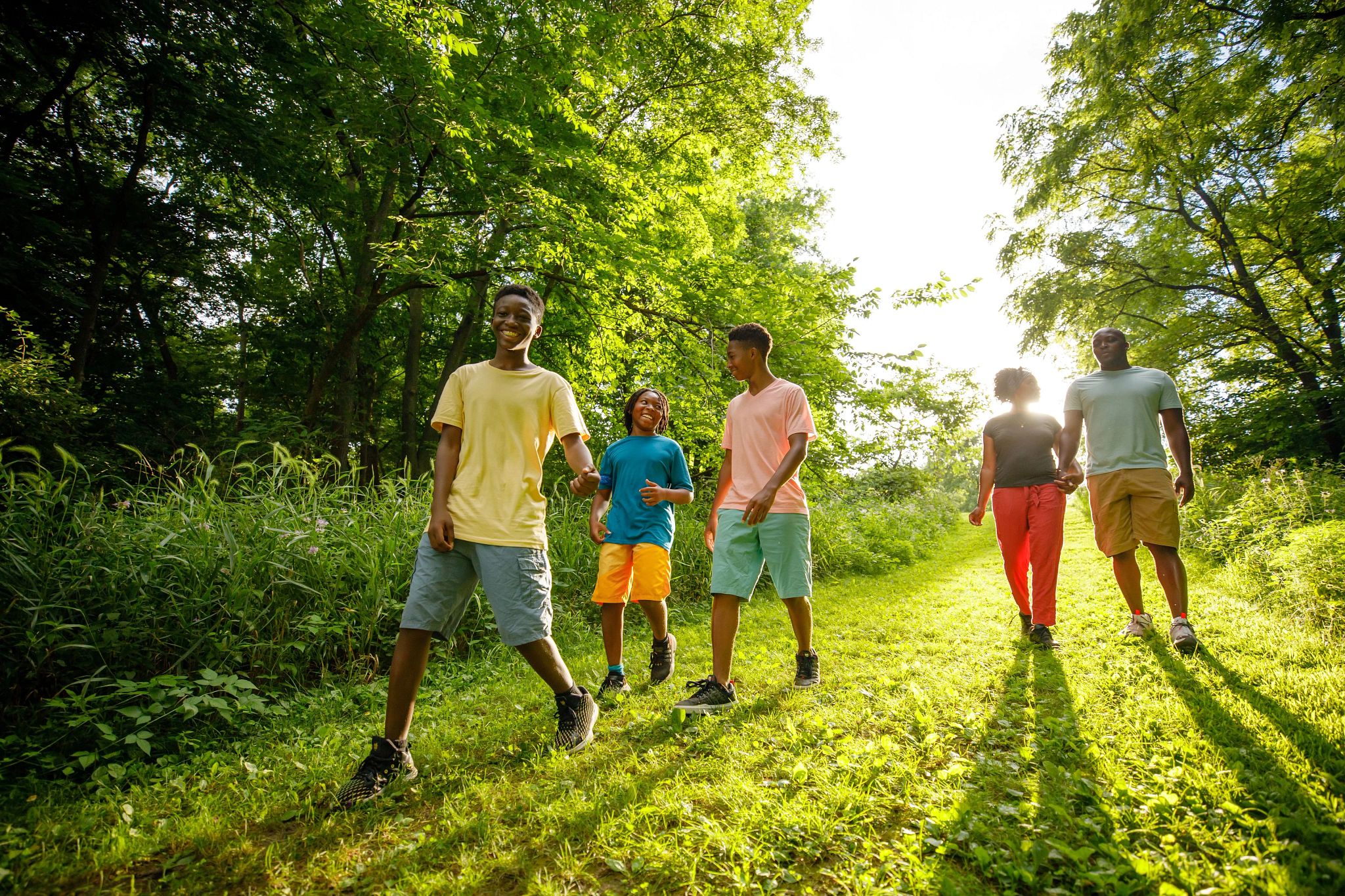 A family walking down a green park path