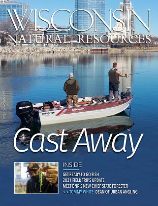 Magazine cover of two men fishing boat with Milwaukee skyline in background