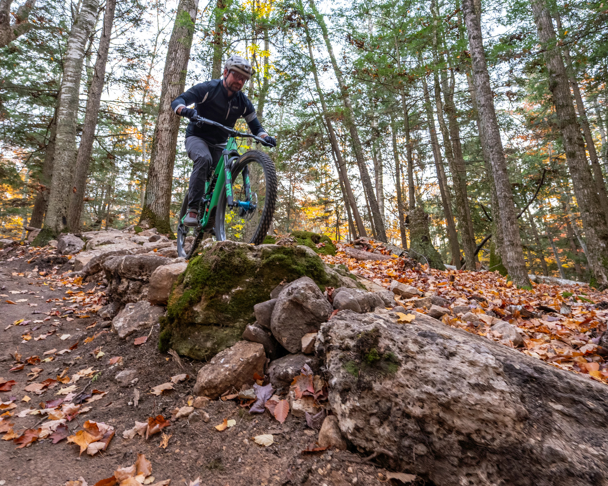 A mountain biker perched atop a slope, ready to descend. 