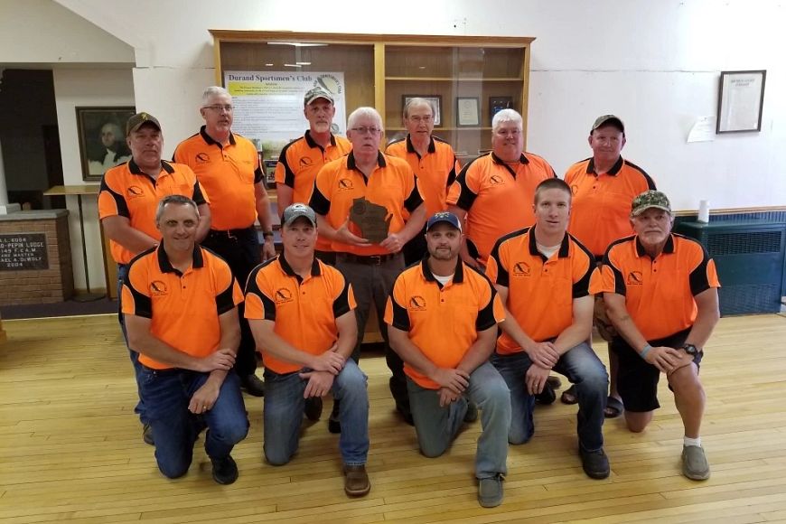 The 12 members of the Durand Sportsmen’s Club of Pepin County wearing orange shirts and posing for a photo.