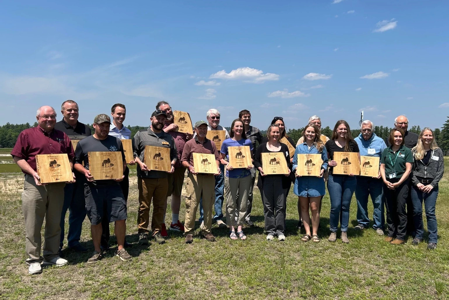 Recipients of the 2025 Invasive Species Action Awards stand with their plaques.