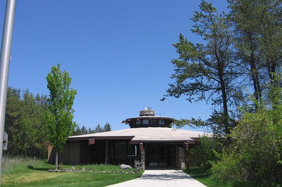 The visitor center at the Kettle Moraine State Forest - Northern Unit, surrounded by trees and blue skies. 