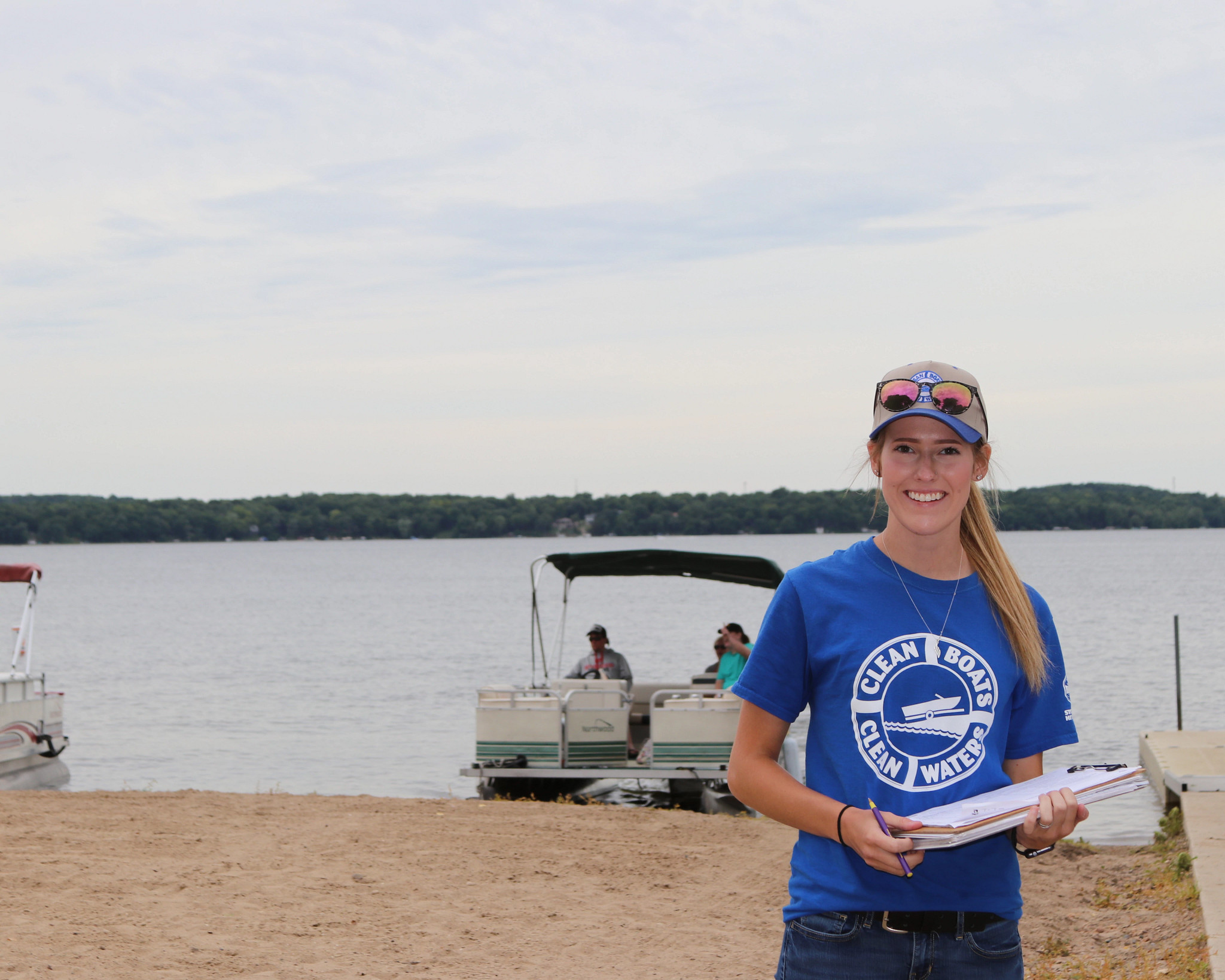 A CBCW volunteer stands near a boat dock. 