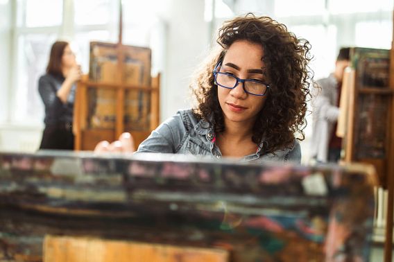 African American female student drawing during a class at art school.