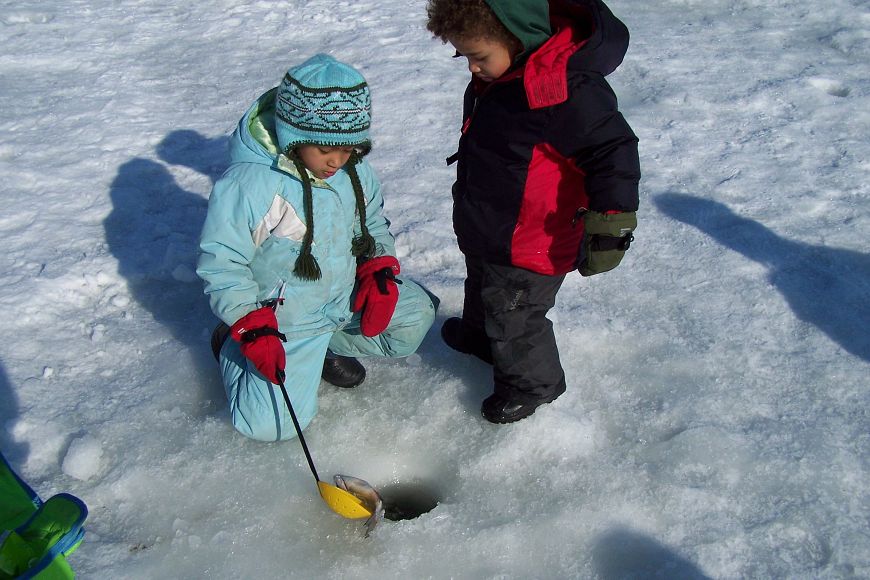 two young kids ice fishing in winter gear