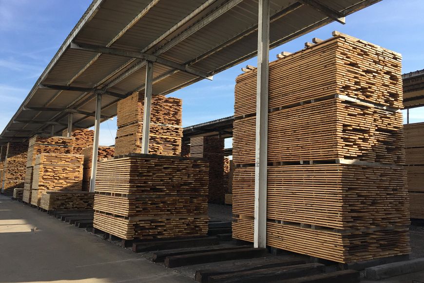 lumber stacked under a covered storage area
