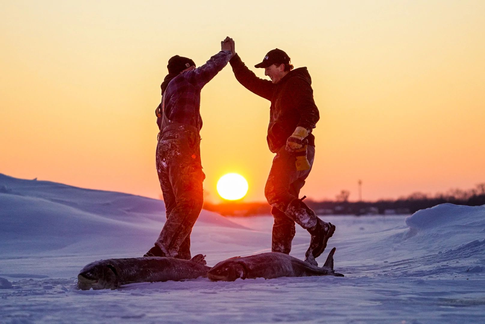 An image of two sturgeon spearers celebrating. 