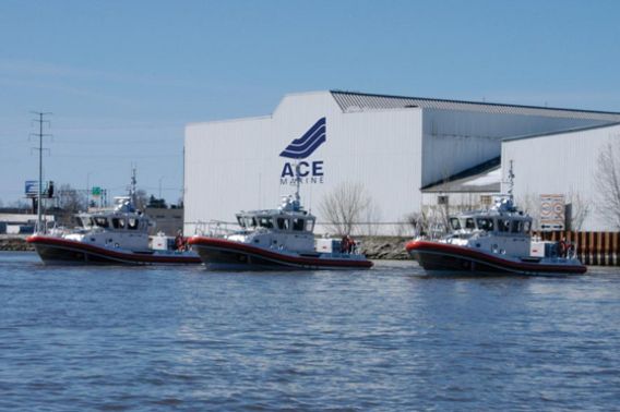 Three large boats sit in a harbor. A large white building behind them reads "ACE Marine."