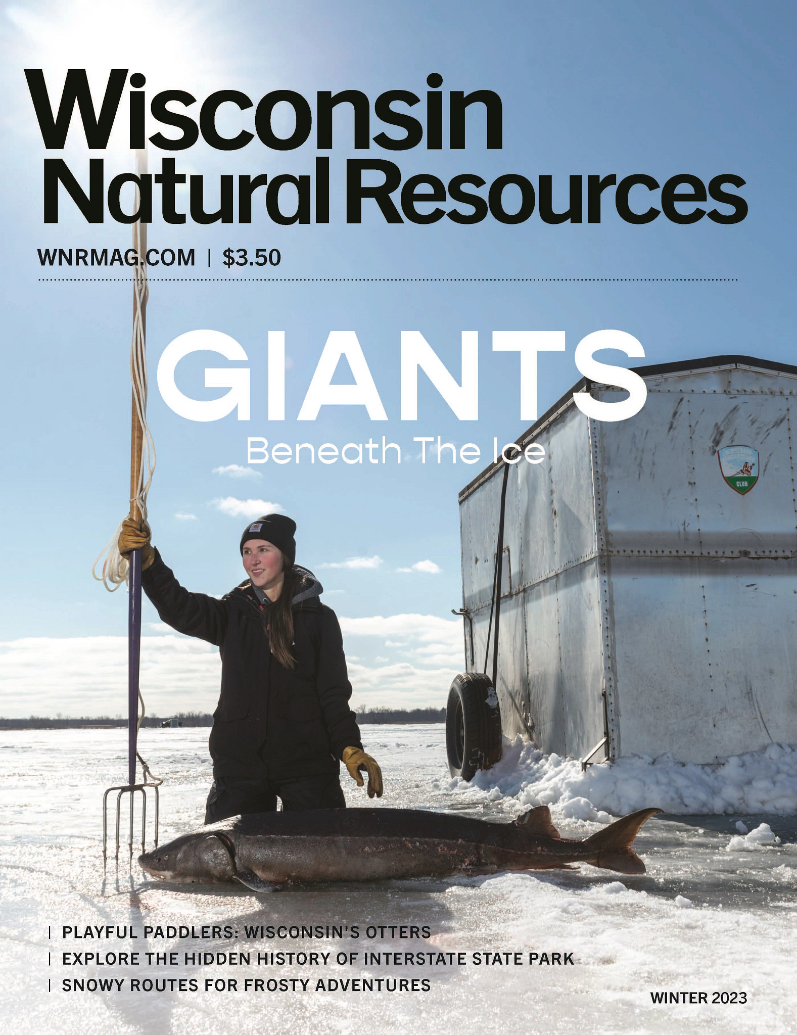 front cover of winter issue of wisconsin natural resources magazine showing woman kneeling on ice with spear and sturgeon