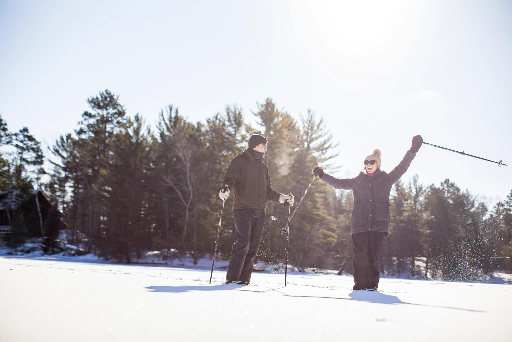 Friends Snowshoe Across A Frozen Lake