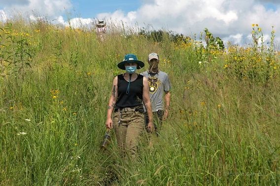 two people in masks walking in prairie