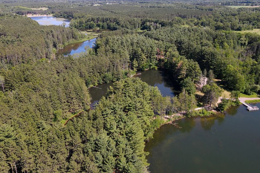 a drone photo of Hartman Creek State Park with four bodies of water and lots of green trees
