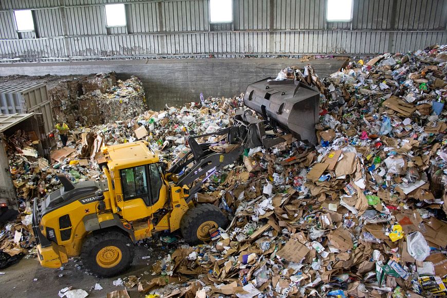 a front loader pushes recyclables