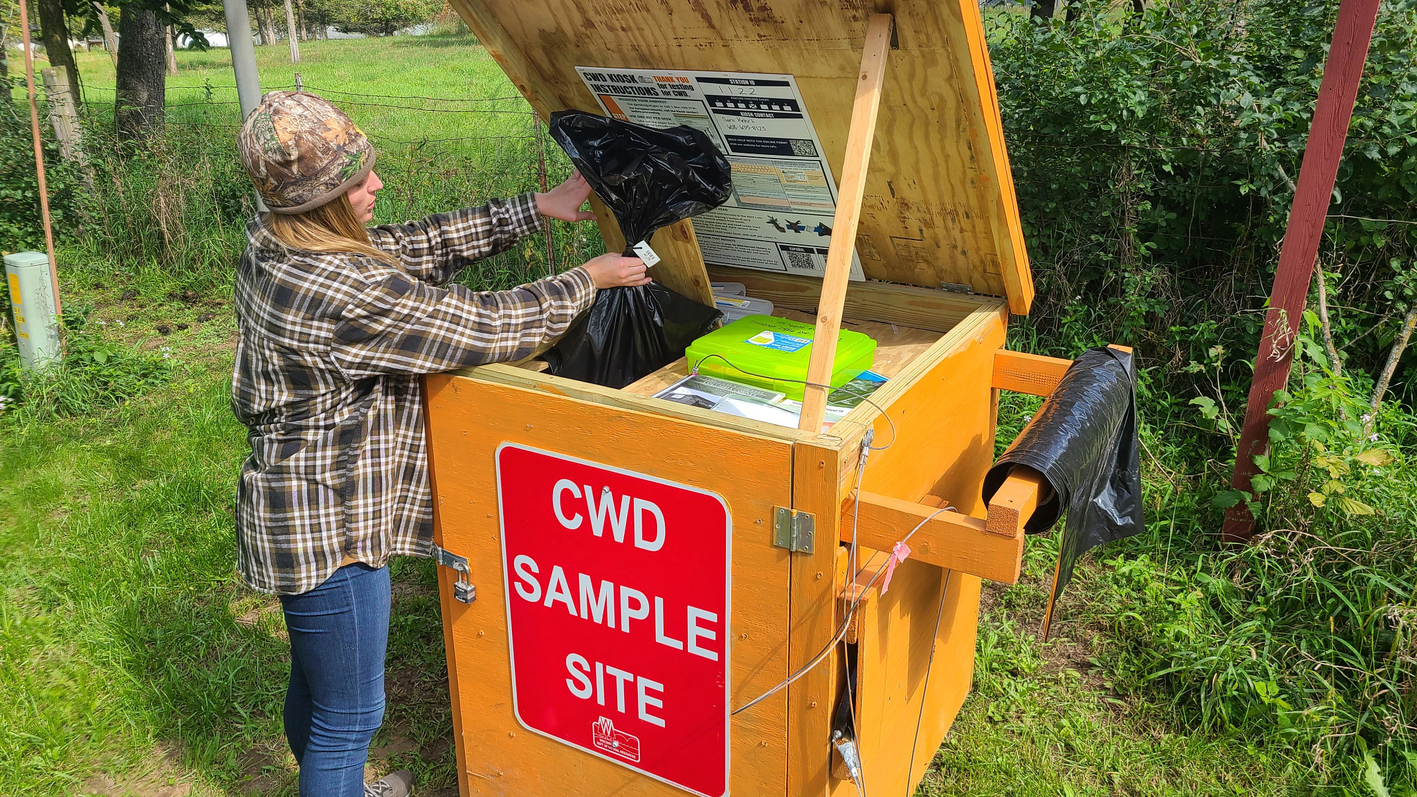 A hunter drops off a sample at a CWD testing kiosk.
