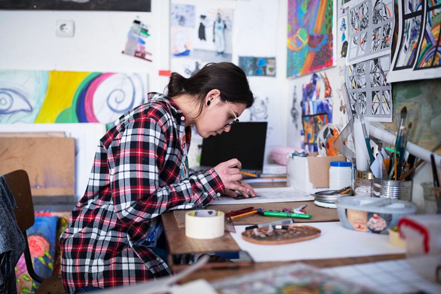 A young woman drawing in an art studio.
