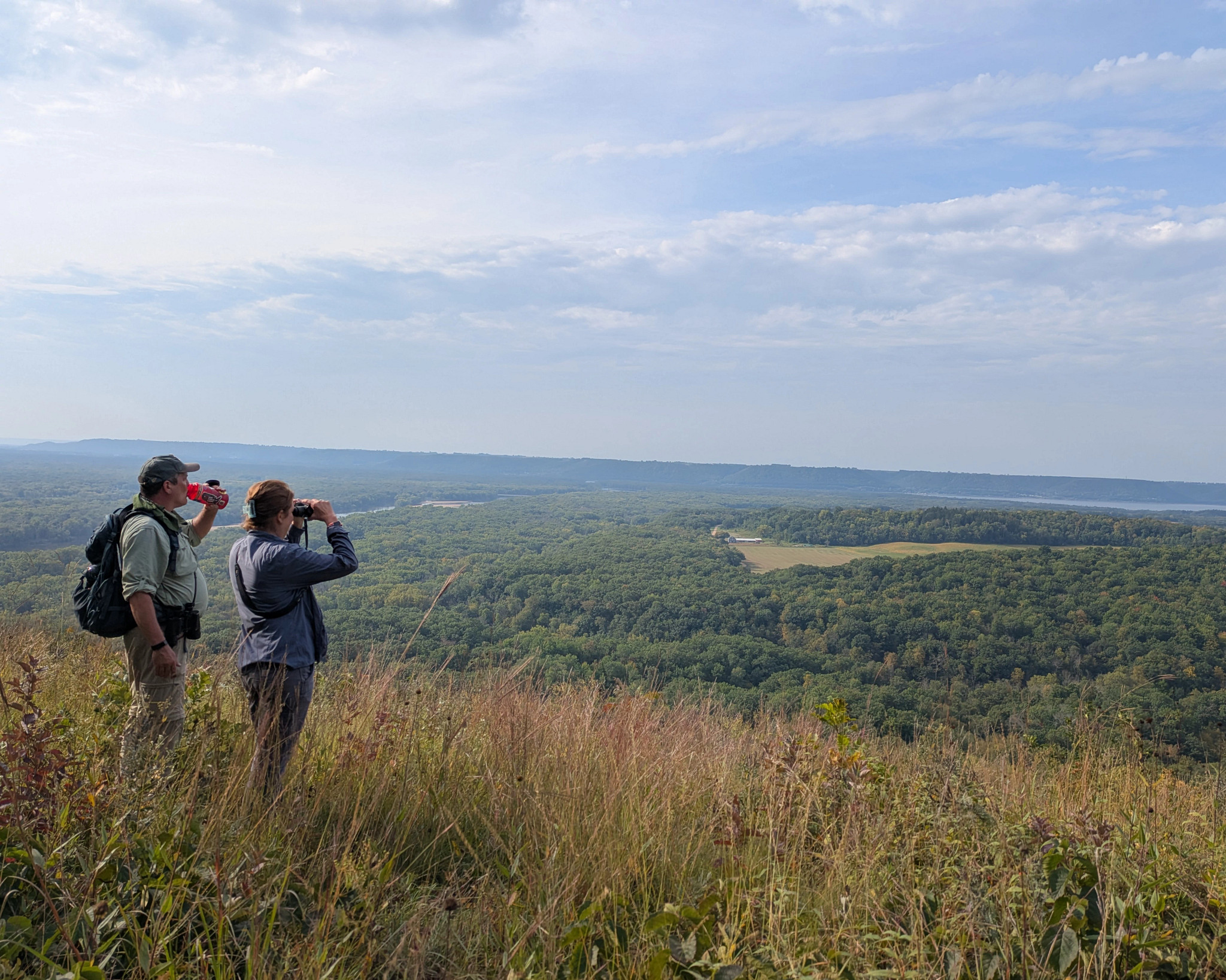 Two tourgoers gaze out at a beautiful overlook.