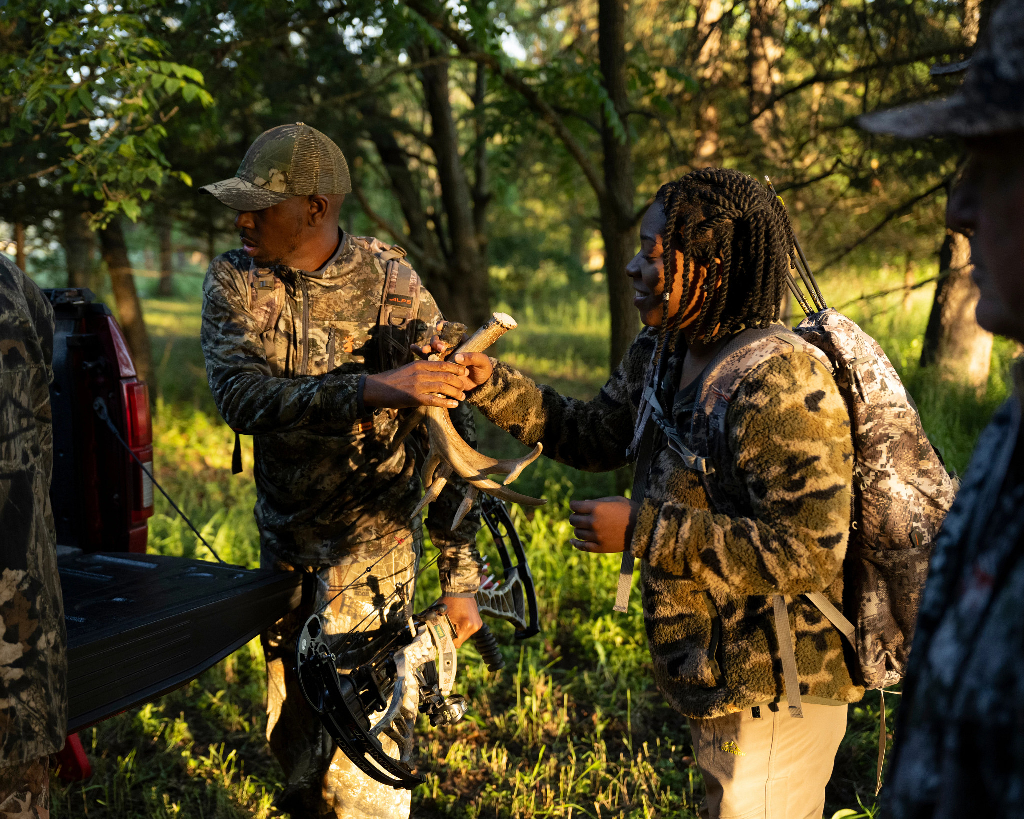 Four hunters gather around a truck, ready to hunt. 