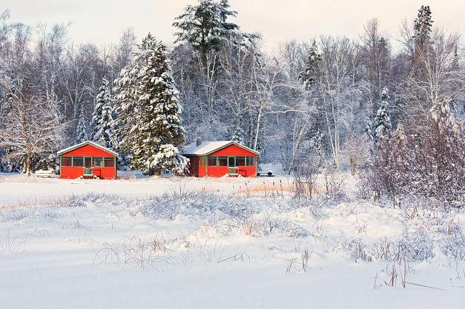 two bright red cabins on a snowy landscape