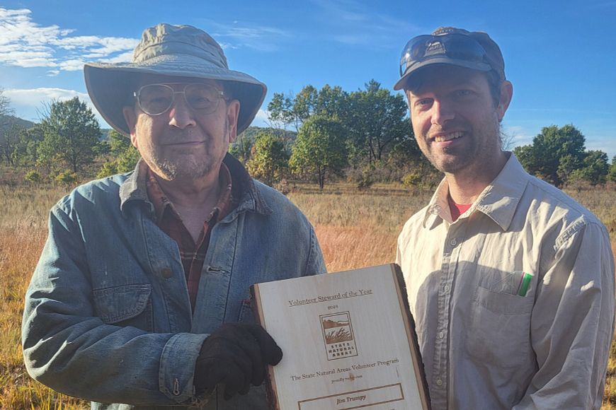 Jim Trumpy standing next to DNR staffer Jared Urban, accepting his award.