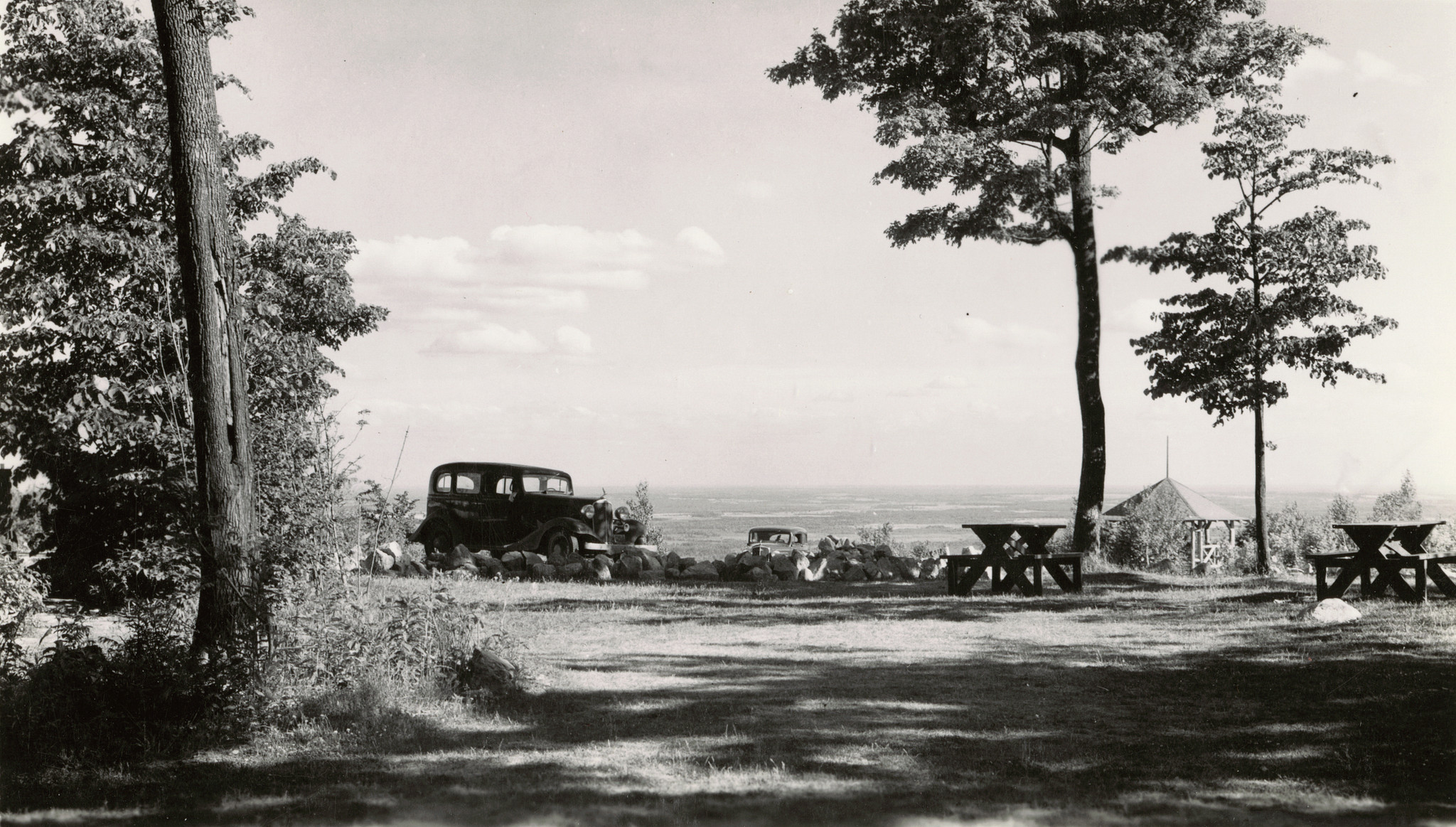 Black and white photo of old car in a state park campground.