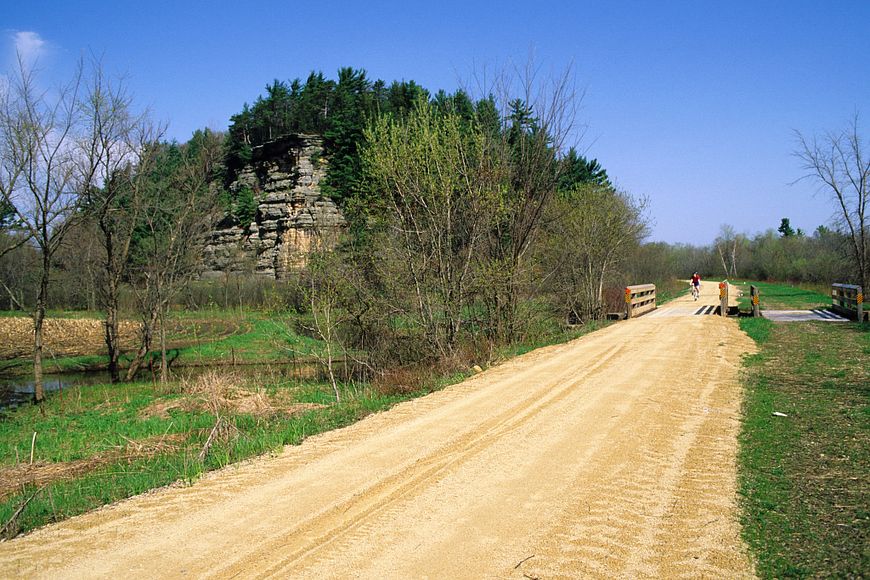 A view of a gravel portion of the 400 State Trail with a rock formation to the left.