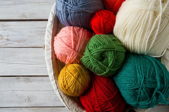 A basket full of various colors of yarn.