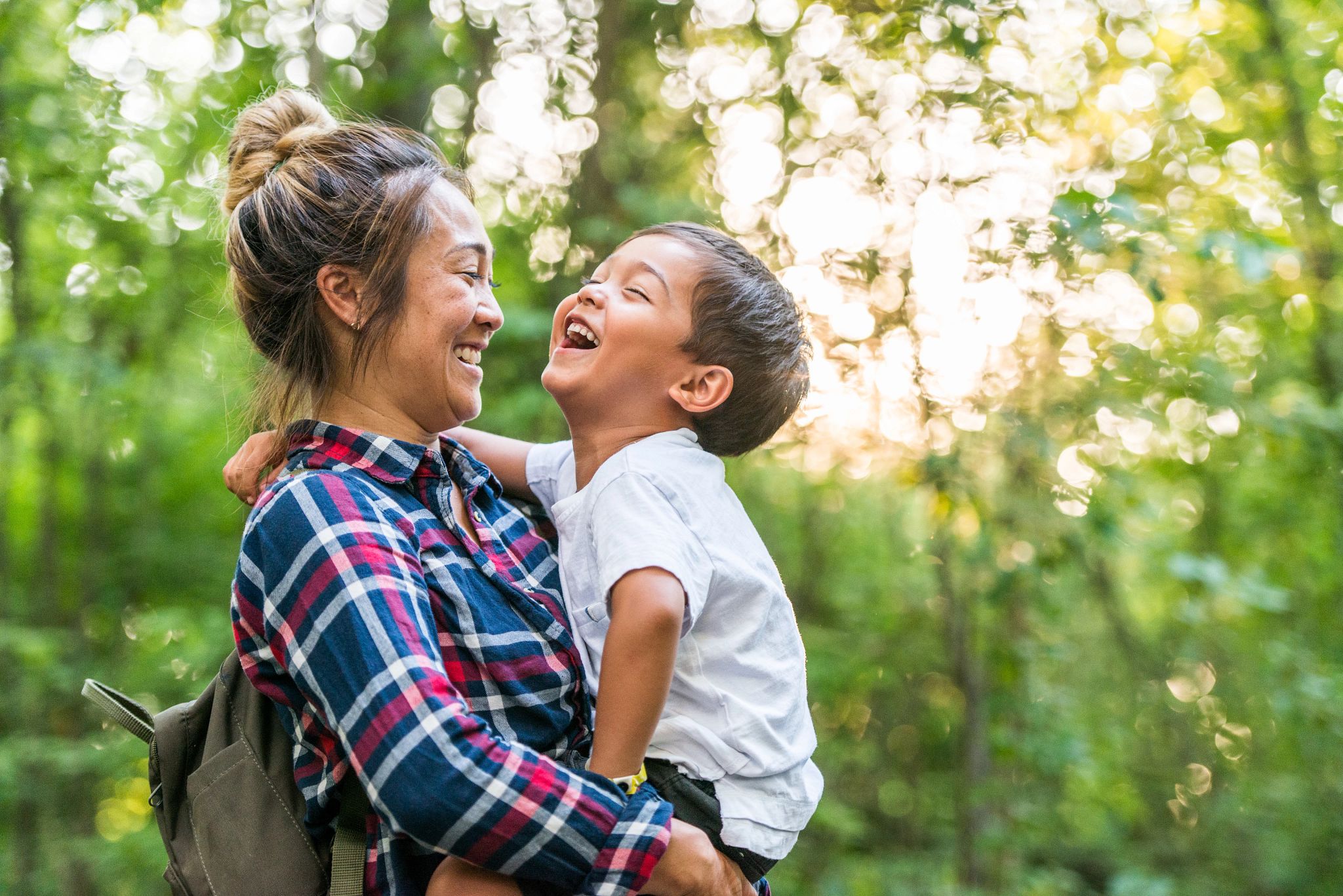 Image of a mother and son smiling together while outdoors. 