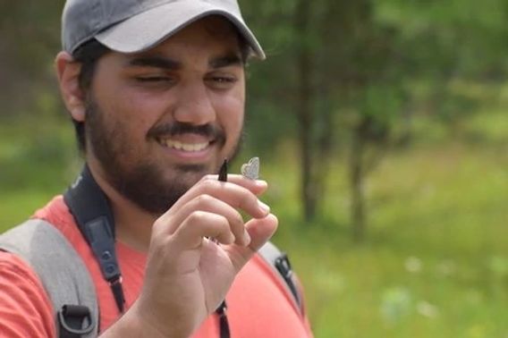 A 2022 summer intern with a blue butterfly