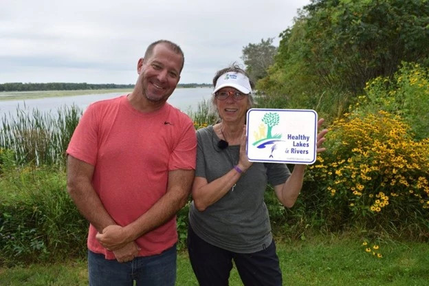 Patrick Kilbey, Marquette County Conservationist, and Healthy Lakes & Rivers Landowner Participant, Karyn Niin Kitigade standing in front of Karyn’s native shoreland planting