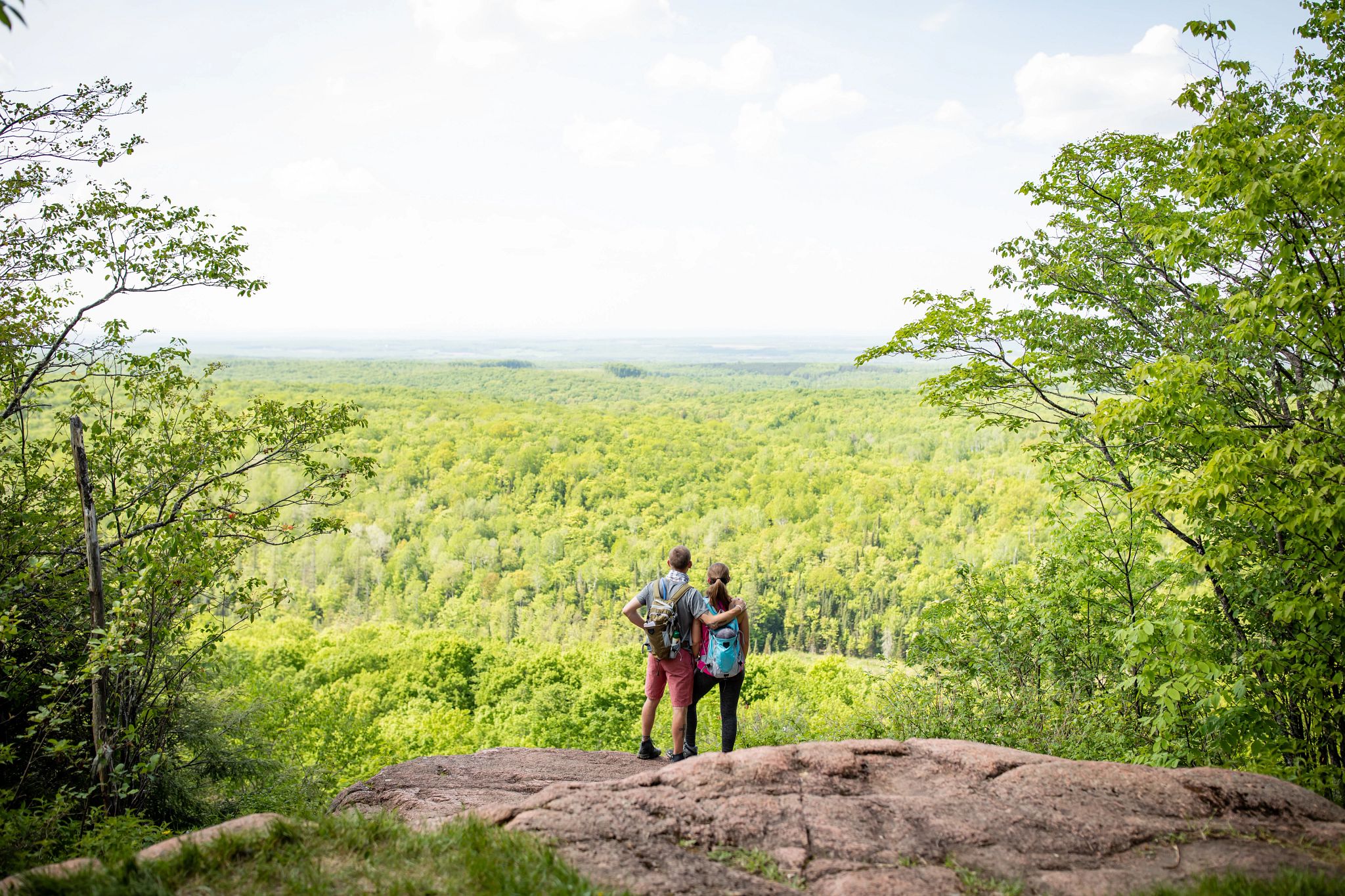 A couple standing on a rock overlook